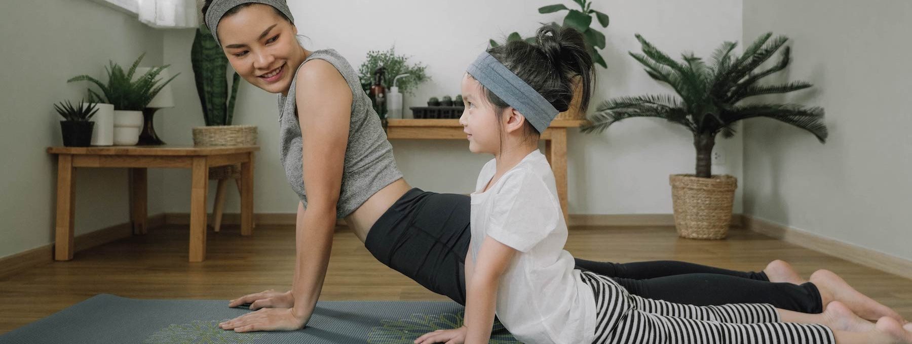 a woman and child doing yoga together at The The Huxley