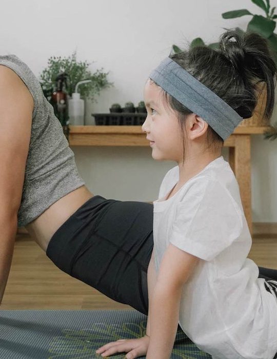 a woman and child doing yoga together at The The Huxley