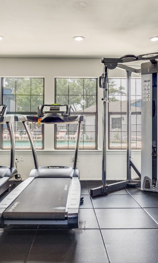 a gym room with treadmills and exercise equipment at The The Huxley