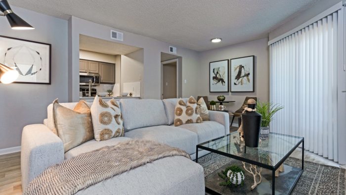 a living room with a couch, coffee table and television at The The Huxley