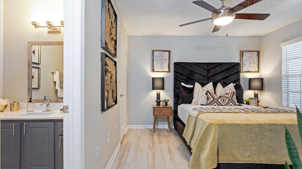 a bedroom with a bed, a ceiling fan and a mirror at The The Huxley